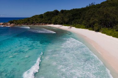 Seyşeller 'deki La Digue' de Anse Cocos plajının huzur verici cazibesini keşfedin. El değmemiş turkuaz sular, parlak mavi gökyüzünün altında yumuşak beyaz kuma nazikçe sarılarak, cennet gibi bir kaçış yaratıyor..