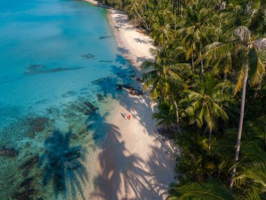 Koh Kood 'daki Takhian Sahili, çarpıcı turkuaz suları ve yumuşak beyaz kumları olan tropikal bir cennettir. Tomurcuklanmış palmiye ağaçları, ziyaretçiler dinlenirken gölgelik sağlar ve doğal güzellikleri kucaklarlar..