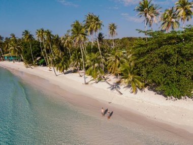 Koh Kood, Tayland 'daki Khlong Hin Sahili' nin sakin kıyılarını keşfedin. Bereketli palmiye ağaçları kıyı şeridinde ziyaretçiler, berrak mavi gökyüzünün altındaki sıcak, davetkar sularda gezinirken..