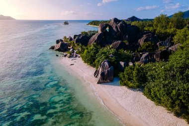 La Digue, Seyşeller 'deki Anse Source d' Argent plajının muhteşem güzelliğini keşfedin. Simgesel granit kayaları, berrak suları ve yemyeşil sularıyla mükemmel bir tropikal cennet yaratıyor..