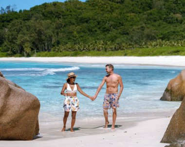 Nefes kesici granit kayalar ve ışıl ışıl turkuaz okyanusla çevrili Anse Cocos plajında iki kişi el ele yürüyor. La Digue Seyşeller