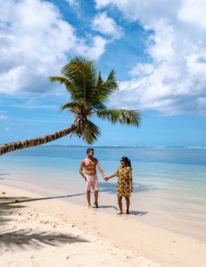 Bu güzel sahne, Seyşeller 'deki Anse Royale plajının el ele tutuşmuş el ele tutuşan bir çifti gösteriyor. Temiz turkuaz sular ve kabarık bulutlar sakin atmosferi güçlendirir..