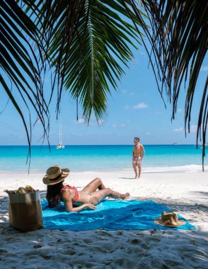 Güneşle öpülen ziyaretçiler Anse Georgette 'de sakin bir günün tadını çıkarıyorlar. Etrafı çarpıcı mavi sular ve yumuşak beyaz kumlarla çevrili. Praslin, Seyşeller