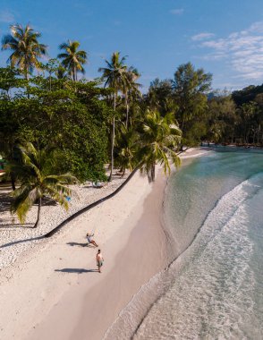 Yumuşak kumların kristal berrak sularla buluştuğu Khlong Hin Sahili 'nin dingin güzelliğini deneyin. Rahatlamak için ideal bir yer. Koh Kood, Tayland 'da tatil yapan birkaç erkek ve kadın.