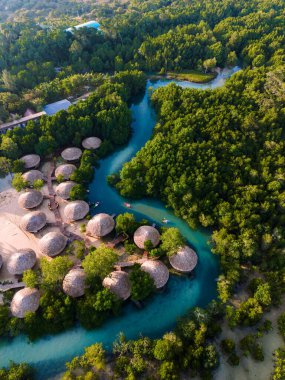 Tayland 'daki Koh Phayam Adası' nda canlı mangrovların arasına yerleştirilmiş büyüleyici sahil barakaları bulunuyor..