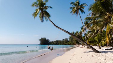 İki arkadaş, Khlong Hin Sahili 'ndeki bir palmiye ağacında, açık mavi gökyüzünün altında, yumuşak beyaz kum ve canlı yeşillikle çevrili bir şekilde sallanıyor. Koh Kood, Tayland dinlenmek için mükemmel bir tatil yeri..