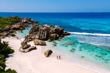 Ziyaretçiler, bereketli yeşillik ve çarpıcı kaya oluşumlarıyla çevrili La Digue Adası 'ndaki Anse Cocos plajlarında geziniyorlar. Seyşeller