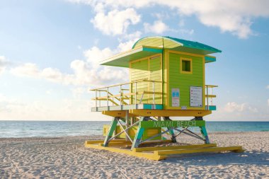 Renkli cankurtaran kulesi Miami Sahili 'nin altın kumu üzerinde gururla duruyor. Bölgenin canlılığını gözler önüne seriyor. Güneş ışığı dalgaların üzerinde dans eder, ziyaretçileri dinlenmeye ve kumsalın tadını çıkarmaya davet eder..