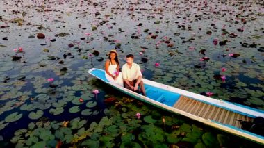 Nong Harn Gölü 'nün güzelliğini keşfedin. Orada canlı kırmızı nilüfer çiçekleri huzur içinde yüzer. Bir çift, Udon Thani 'de büyüleyici doğayla çevrili romantik bir tekne gezisinden hoşlanıyor. Kızıl Lotus denizi Tayland