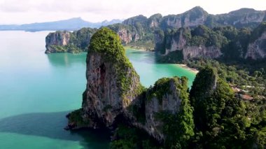 Tayland, Krabi 'deki Railay Sahili' nin güzelliğini büyüleyici kireçtaşı oluşumları ve canlı turkuaz sularıyla yaşayın. Rahatlama ve macera için mükemmel bir yer gezginleri bekliyor..