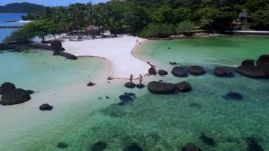 Tayland 'daki Koh Kham Trat' ın sakin manzaralarını deneyin. Güneş banyosu yapanlar sakin plajların, masmavi suların ve bereketli palmiye ağaçlarının tadını çıkarırlar. Tropik bir cennetten mükemmel bir tatil kaçışı yaratırlar..