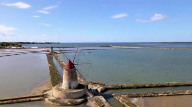 Marsala, Sicilya 'nın büyüleyici tuzluklarını keşfedin. Canlı suların ve berrak gökyüzünün arkaplanına karşı tarihi yel değirmenlerini sergileyin. Rahatlatıcı bir kaçış ya da macera için mükemmel..