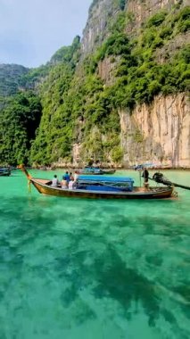 Koh Phi Phi, Krabi, Tayland 'ın nefes kesici güzelliğini tecrübe edin, canlı turkuaz suların yemyeşil kayalıklarla buluştuğu yer..