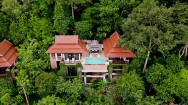 Turkuaz havuzun canlı tropikal ağaçlarla buluştuğu Krabi Tayland 'da güzel tasarlanmış bir villanın huzurlu atmosferinin tadını çıkarın. Huzurlu bir kaçış ve rahatlama için mükemmel..