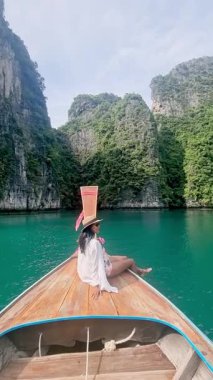 Uzun kuyruklu bir tekneyle turkuaz sularda süzülürken Koh Phi Phi Tayland 'ın göz kamaştırıcı manzaralarını görün. Bu tropikal cennette, yüksek uçurumların ve yemyeşil yeşermenin ortasında rahatla..