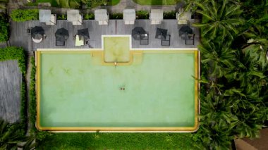 Tayland, Krabi 'deki güzel bir havuzun huzurlu atmosferini hissedin. Huzurlu ortamda palmiye ağaçları, rahat dinlenme yerleri ve suyu cennete davet eden bir rahatlama var..