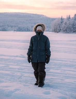 Finlandiya, Akaslompolo Village 'da sakin bir kış sahnesiyle karşılaşın. Asyalı kadın kışın Laponya 'yı ziyaret ediyor