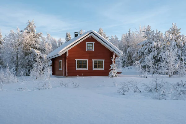Akaslompolo, Laponya, Finlandiya 'da kışın dingin güzelliğini, karla kaplı ağaçlarla çevrili çarpıcı kırmızı bir kulübeyle yaşayın. Huzur arayan gezginler için mükemmel bir dinlenme yeri..