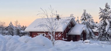 Bu davetkar kırmızı kulübe Akaslompolo, Laponya 'da bir kış harikalar diyarında bulunuyor. Kar zemini ve ağaçları örtüyor, alacakaranlıkta sakin bir atmosfer yaratıyor, rahat bir kaçış için mükemmel..
