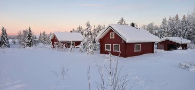 Derin kara gömülü sıcak kırmızı kulübeler Laponya, Akaslompolo 'nun huzurlu güzelliğini gösteriyor. Bu büyüleyici sahne Finlandiya 'nın vahşi doğasının sükunetini ve kış sihrini gözler önüne sermektedir..
