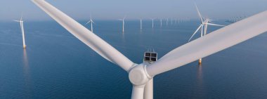 Açık deniz rüzgâr türbinleri Kuzey Denizi 'nde zarifçe dönerek temiz elektrik, denizaşırı rüzgar türbinleri, Hollanda' da yeşil enerji ve enerji geçişi üretiyor.