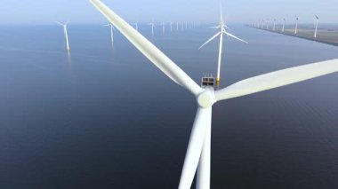 Hollanda açıklarında okyanusta temiz elektrik üreten rüzgar türbinlerinin çarpıcı manzarasına bakın. Bu sahnede yenilenebilir enerji iş başında, sürdürülebilirliği destekliyor.