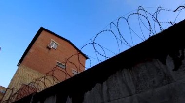 Beton bir çitin üzerine dikenli tel gerilmiş. Koruma Alanı