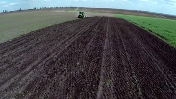 El tractor afloja el terreno en el campo. Imágenes aéreas. Volar sobre un tractor en un campo — Vídeo de stock