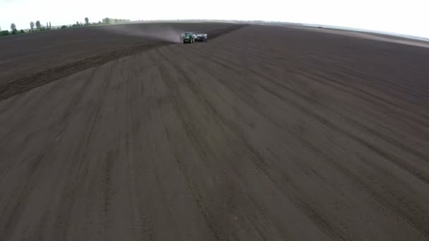 Traktor mit Pflanzmaschine bei der Feldarbeit. über das Feld fliegen — Stockvideo