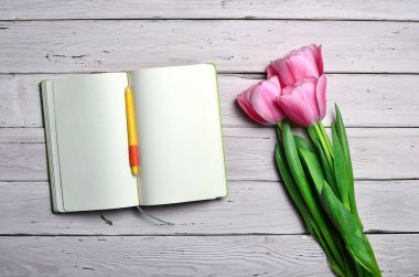 Boş sayfaları, davetiye için pembe laleleri ya da beyaz ahşap arka planı için tebrikler. Üst görünüm, alanı kopyala.