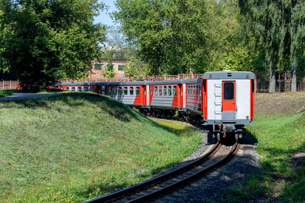 The train departs around the bend. Back view. Russian children\'s railway in Novomoskovsk in August 2021.