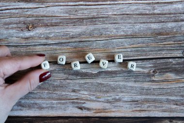 Kadınların parmakları, tahta arka planda 