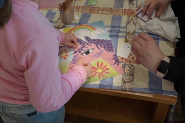 Annesiyle yapboz yapan bir çocuğun ellerinin yakın çekimi. Bir aile olarak öğretme ve öğrenme kavramı