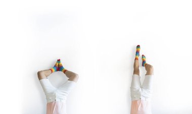 Genç eşcinsel adam beyaz arka planda izole edilmiş gökkuşağı çoraplarıyla amuda kalkıyor. Uzayı kopyala Özgürlük ve LGBT kavramı.