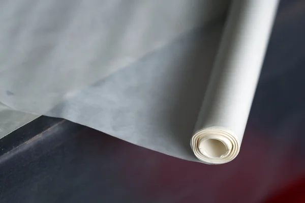 The roll of the tracing paper laying on the table Stock Photo