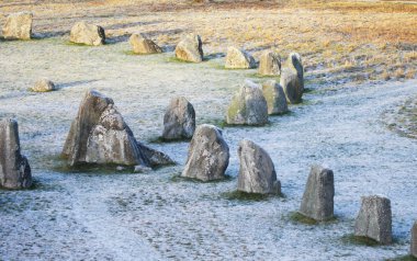 Kışın kar alanında duran büyük taşlar
