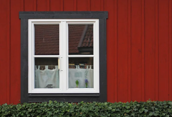 Белое окно в старой красной деревянной стене — стоковое фото