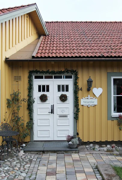 Дверь в старом шведском доме украсили белые ленточки — стоковое фото