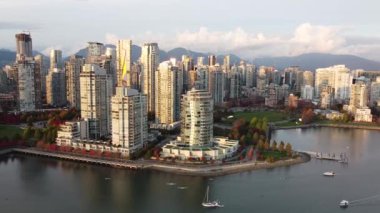 Vancouver 'ın şehir merkezindeki kırmızı yeşil ağaçlı altın bir akşam ışığında çekilmiş fotoğrafı.