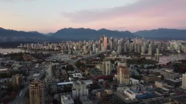 Vancouver 'ın şehir merkezindeki hava görüntüleri ve gece turuncu ışıkta köprüler.