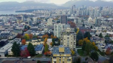 Şehir merkezindeki Vancouver 'ın insansız hava aracı görüntüleri, arka planda renkli ağaçlar ve dağlar.