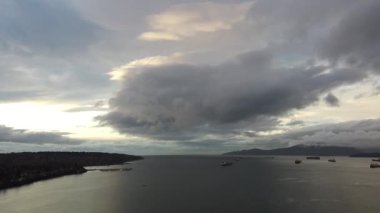 Vancouver yakınlarında kargo gemileri ve akşamları büyük bulut olan körfez manzarası.