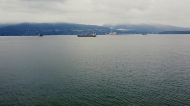 在温哥华附近的水面上空向在阴天等候的货船飞去 — 图库视频影像