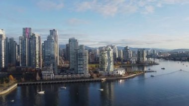 Güneşli bir günde demirlemiş teknelerle Vancouver şehir merkezinin hava manzarası.