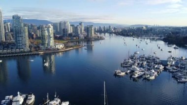 Vancouver 'da güneşli bir sonbahar gününde şehir merkezinde bir manzarayla marina üzerinde uç.