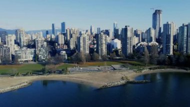 Güneşli bir akşamda Vancouver şehir merkezinin havadan görüntüsü ve İngiliz koyundaki plaj.