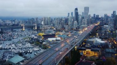Vancouver şehir merkezinin hava manzarası ve gece karanlık bulutlu gökyüzü ile köprü.