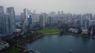 Vancouver şehir merkezindeki gökdelenlerle çevrili yeşil oyun parkının üzerinden uç