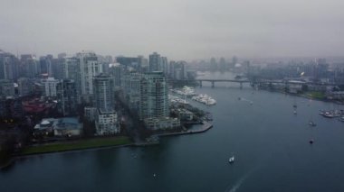 Bulutlu bir günde Vancouver 'daki False Creek' in üzerinden köprünün manzarasıyla uç.