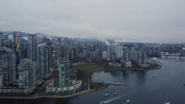 Alçak bulutlar ve arka planda dağlarla şehir merkezinin hava manzarası